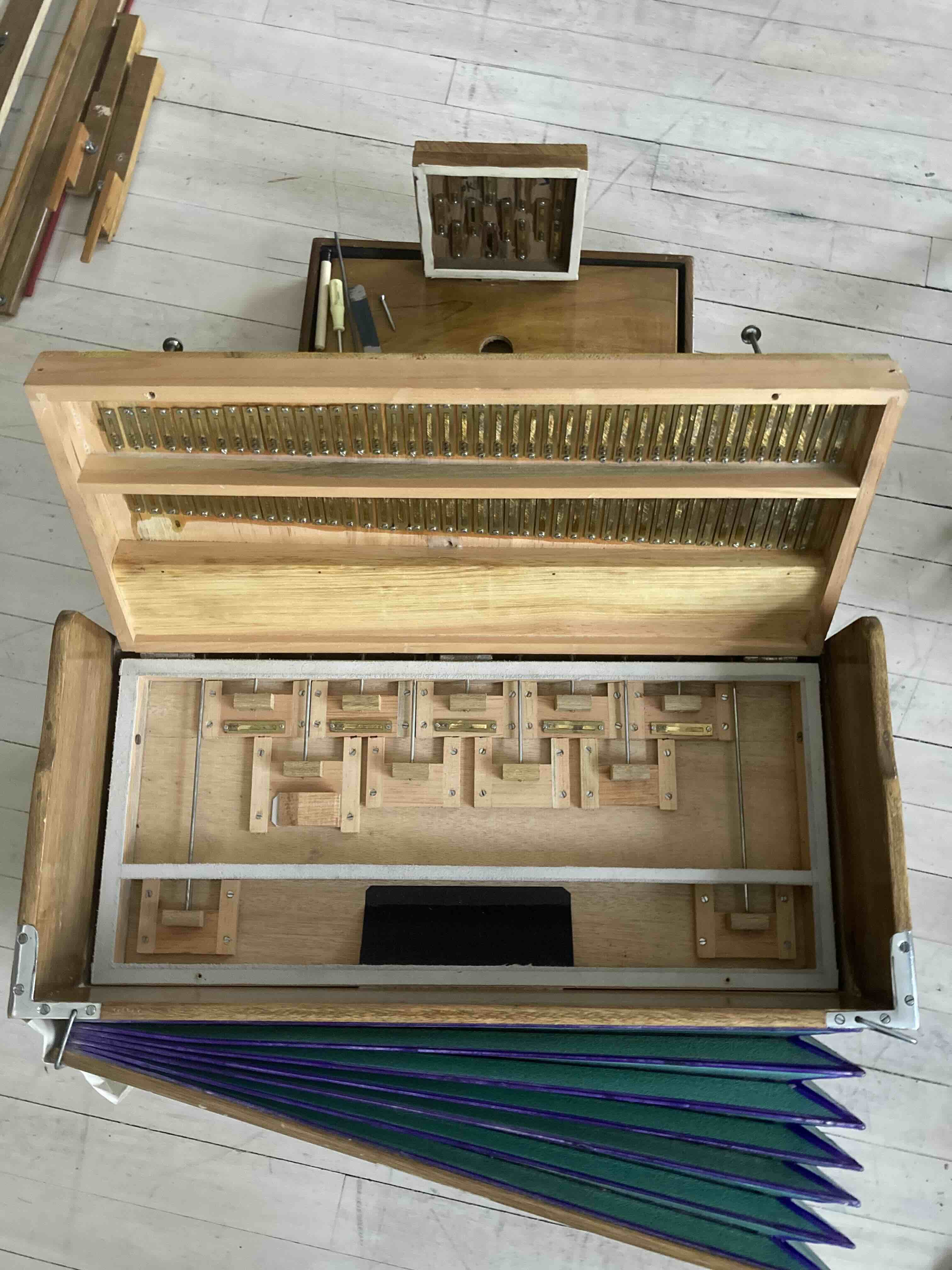 An open harmonium and shruti box with reeds exposed
