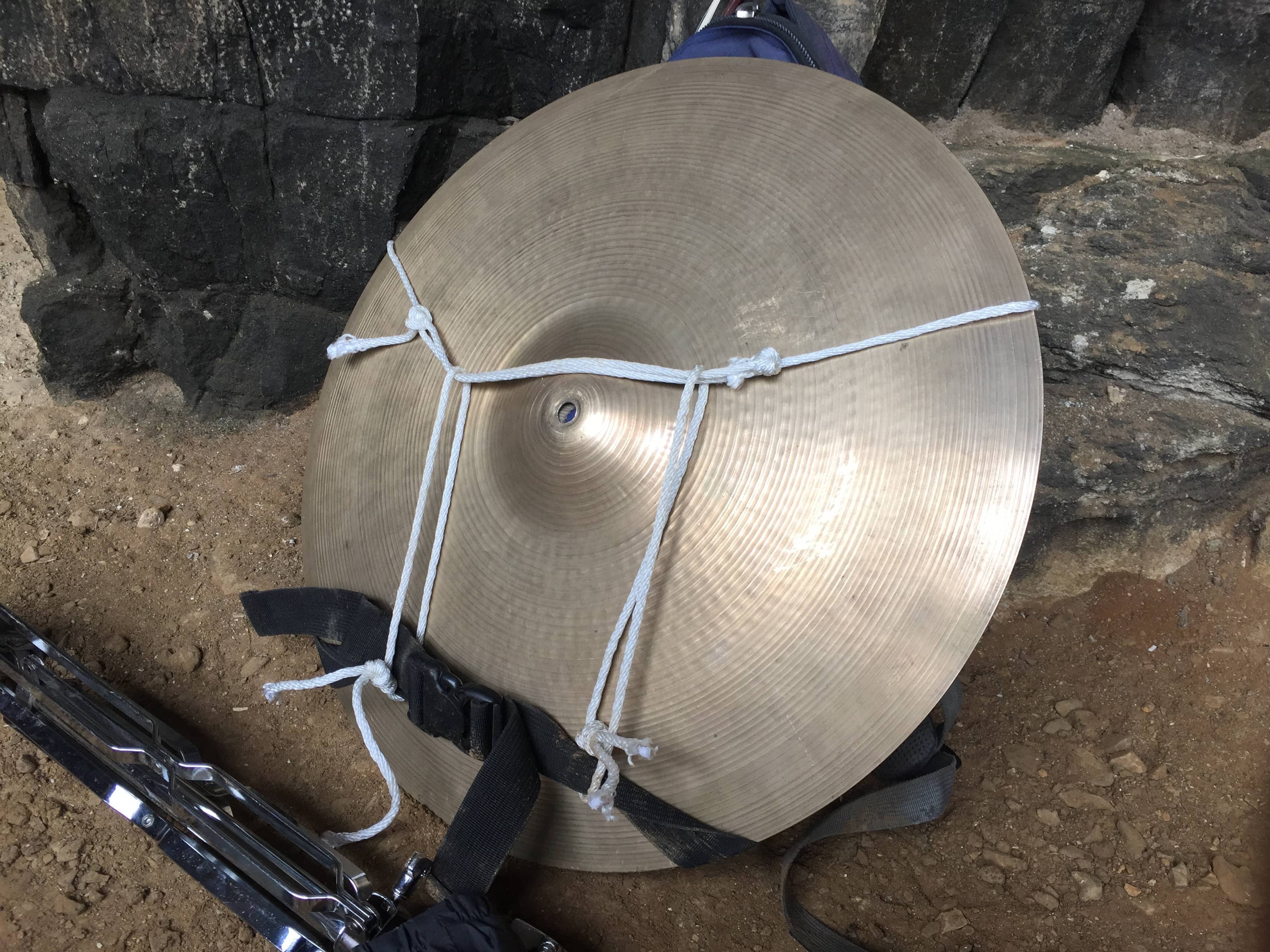 a backpack with a cymbal attached to it in a cave