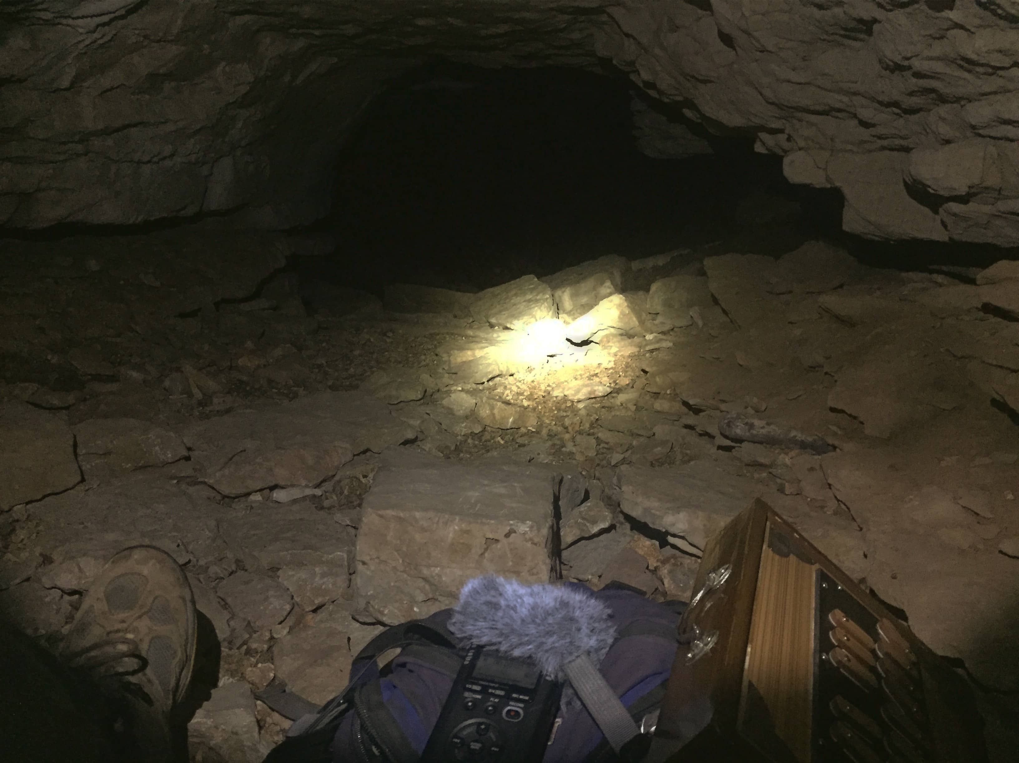 a shruti box and field recorder in a small cave